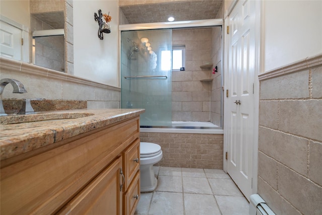 bathroom featuring tile walls, tile patterned flooring, vanity, toilet, and tiled shower / bath combo