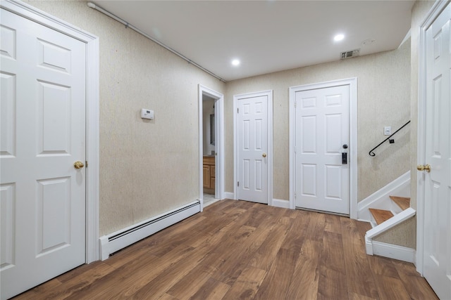 foyer entrance with baseboard heating, stairs, recessed lighting, wood finished floors, and visible vents