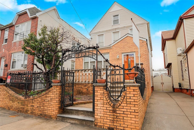 view of front of house with brick siding, a fenced front yard, and a gate