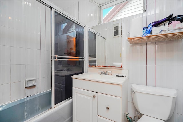 full bath featuring vanity, tile walls, toilet, and enclosed tub / shower combo