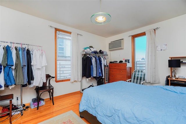 bedroom featuring a closet, a wall mounted air conditioner, and wood finished floors