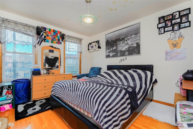 bedroom with baseboards and wood finished floors