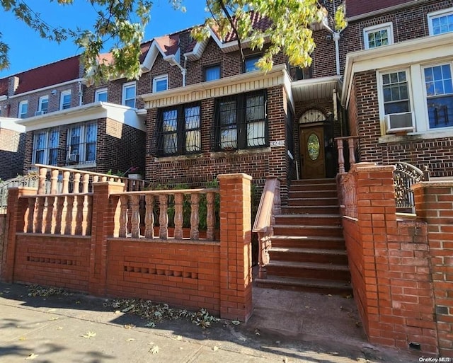 view of front of house featuring cooling unit and brick siding