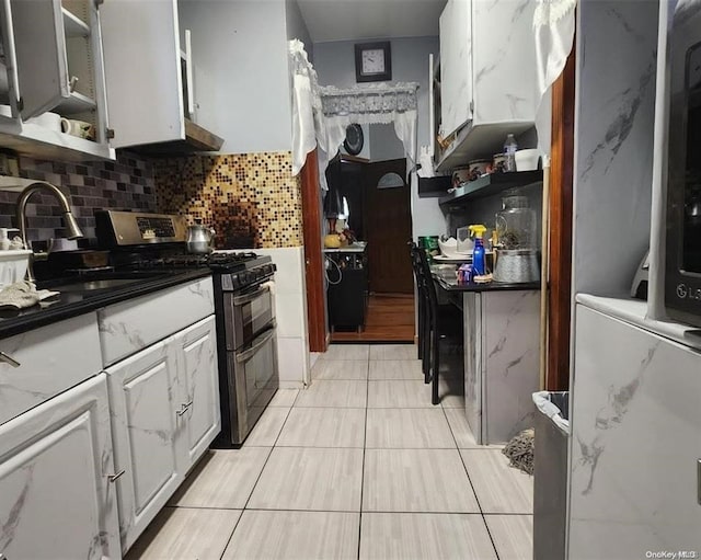kitchen featuring white cabinetry, open shelves, double oven range, and a sink