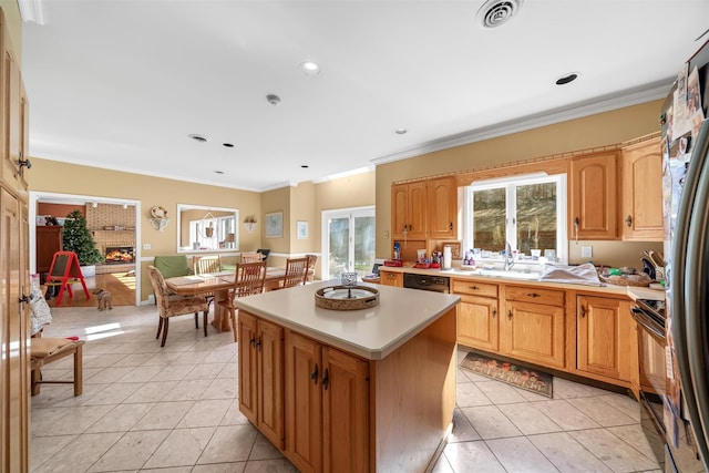 kitchen with light countertops, light tile patterned floors, a center island, a sink, and visible vents