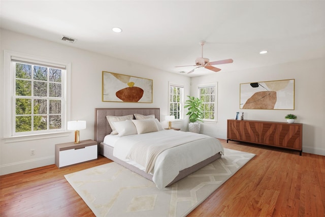 bedroom with a ceiling fan, visible vents, light wood-type flooring, baseboards, and recessed lighting