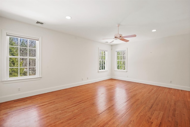unfurnished room with baseboards, a ceiling fan, and light wood-type flooring