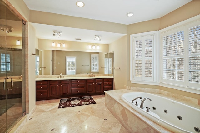 bathroom featuring a sink, a stall shower, a tub with jets, and double vanity