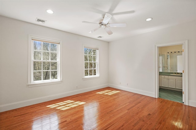 unfurnished room featuring baseboards, visible vents, ceiling fan, and light wood-style floors