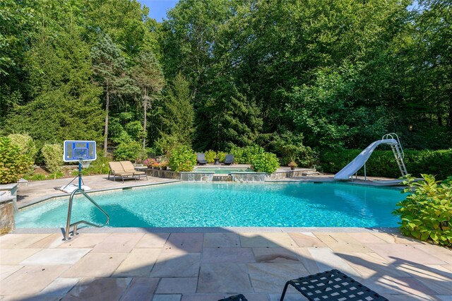 pool featuring a water slide and a patio area
