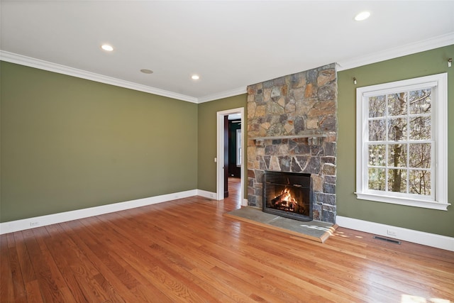 unfurnished living room featuring baseboards, ornamental molding, wood finished floors, and a fireplace