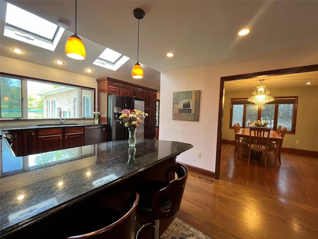 kitchen featuring a sink, fridge with ice dispenser, stainless steel dishwasher, a skylight, and visible vents
