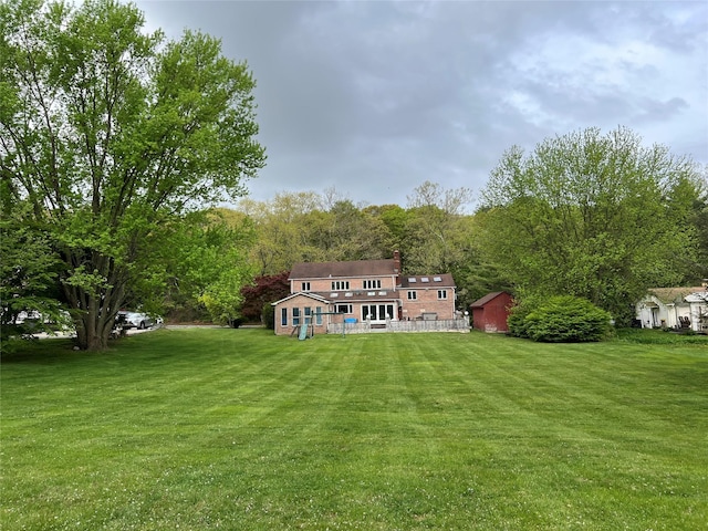 rear view of house with a lawn and a wooded view