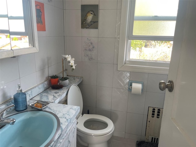 248-29 88th Rd, Bellerose, NY 11426 - bathroom featuring tile walls, toilet, radiator, a sink, and tasteful backsplash