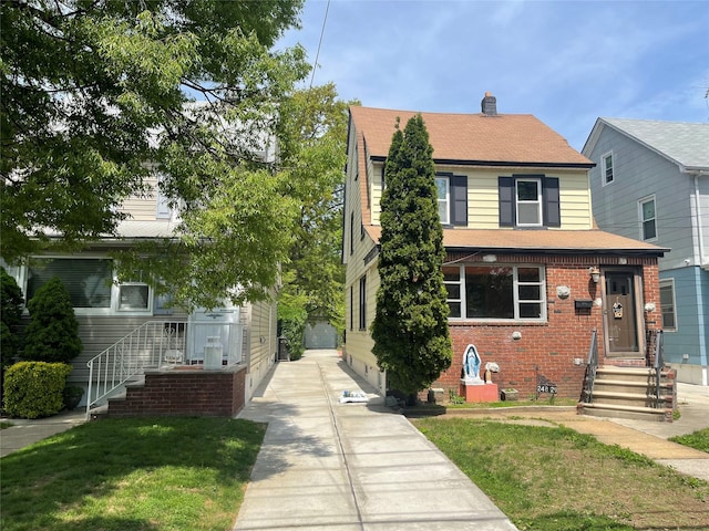 248-29 88th Rd, Bellerose, NY 11426 - view of front of home featuring a chimney, brick siding, entry steps, roof with shingles, and a front lawn