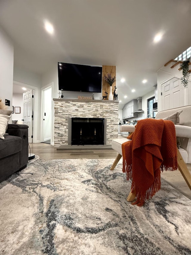 1760 Manatuck Blvd, Bay Shore, NY 11706 - living room featuring recessed lighting, a stone fireplace, and wood finished floors