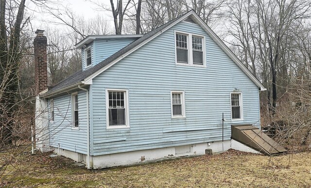 view of side of property with roof with shingles