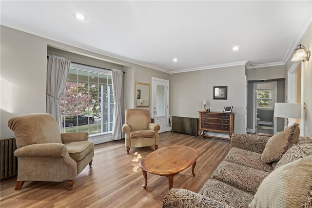 living area with recessed lighting, radiator, wood finished floors, and ornamental molding