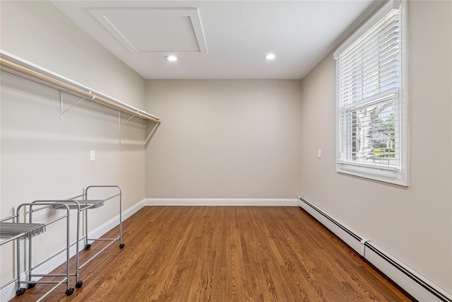 washroom with baseboards, wood finished floors, recessed lighting, and baseboard heating