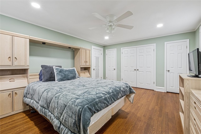 bedroom with multiple closets, wood finished floors, recessed lighting, and crown molding