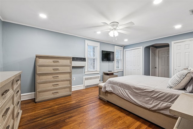 bedroom featuring arched walkways, radiator heating unit, ornamental molding, and dark wood-style flooring