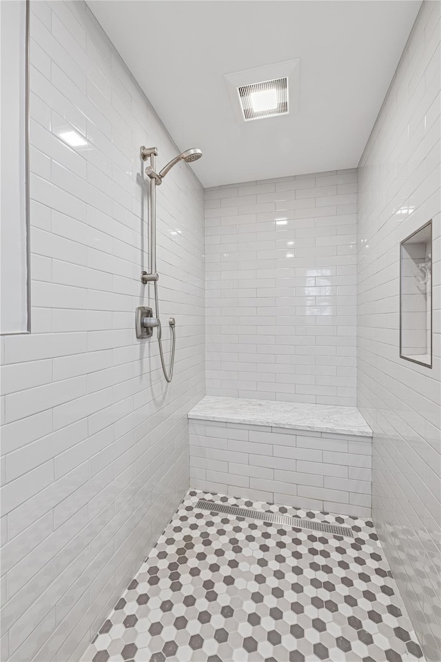 full bathroom with visible vents and a tile shower