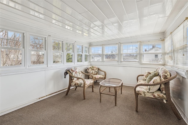 sunroom / solarium with baseboards, carpet flooring, and a healthy amount of sunlight
