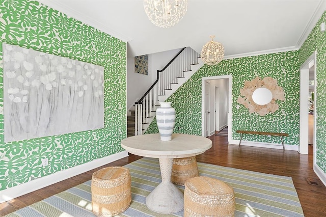 entryway with crown molding, stairs, baseboards, a notable chandelier, and wallpapered walls