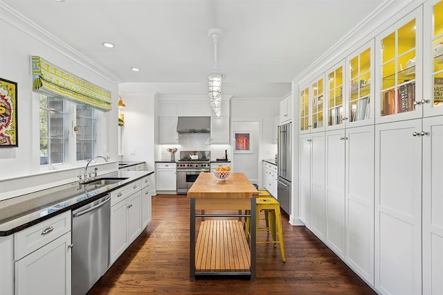 kitchen with crown molding, a sink, white cabinetry, and high quality appliances