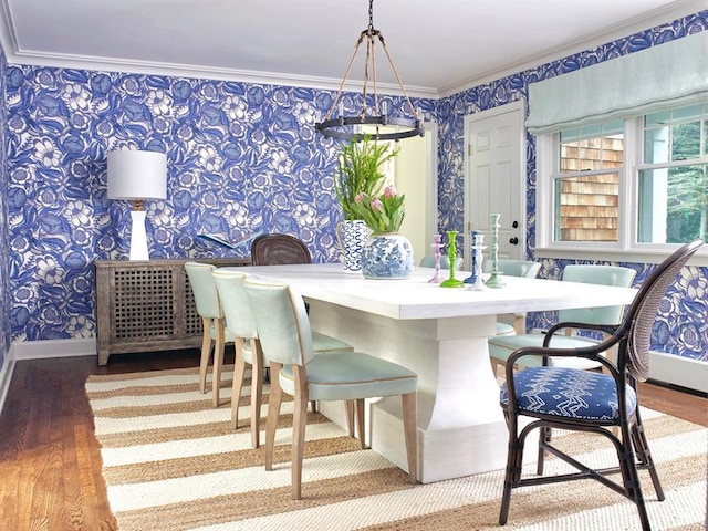 dining space with baseboards, ornamental molding, wood finished floors, and wallpapered walls