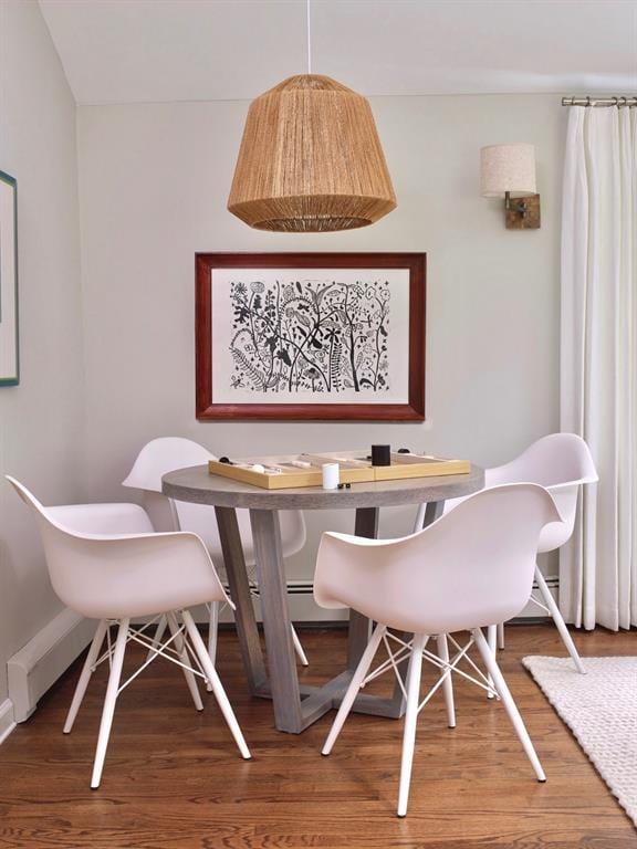 dining space with baseboards and wood finished floors