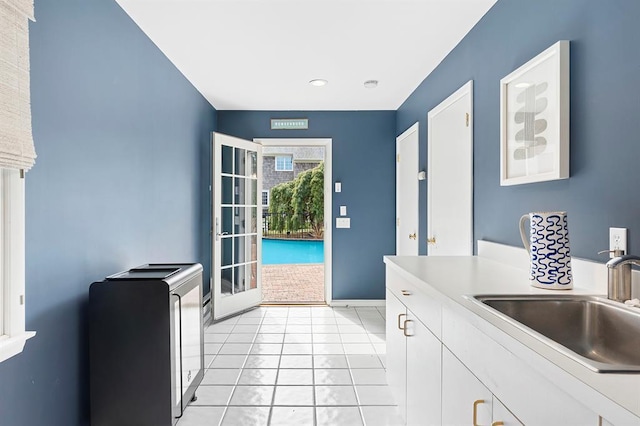 kitchen with a sink, light countertops, recessed lighting, and white cabinetry