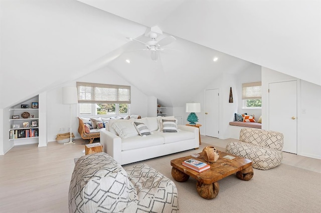 living room featuring lofted ceiling, a healthy amount of sunlight, and light wood-style flooring