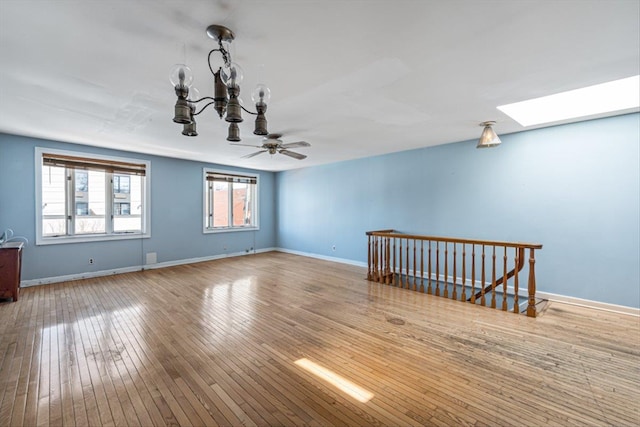 83-18 Parsons Blvd, Jamaica, NY 11431 - unfurnished room with ceiling fan with notable chandelier, a skylight, baseboards, and hardwood / wood-style flooring