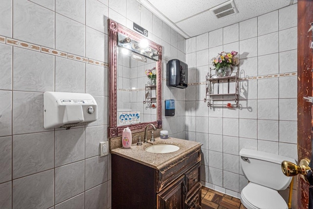 83-18 Parsons Blvd, Jamaica, NY 11431 - half bathroom featuring vanity, tile walls, toilet, and visible vents