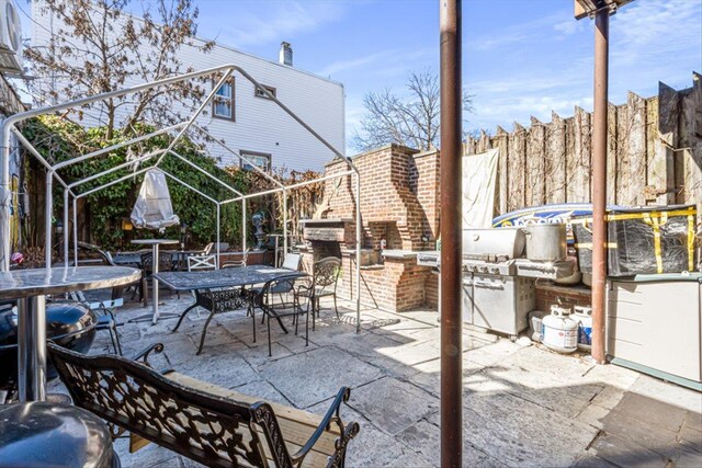 83-18 Parsons Blvd, Jamaica, NY 11431 - view of patio / terrace with a grill, exterior kitchen, outdoor dining space, and fence