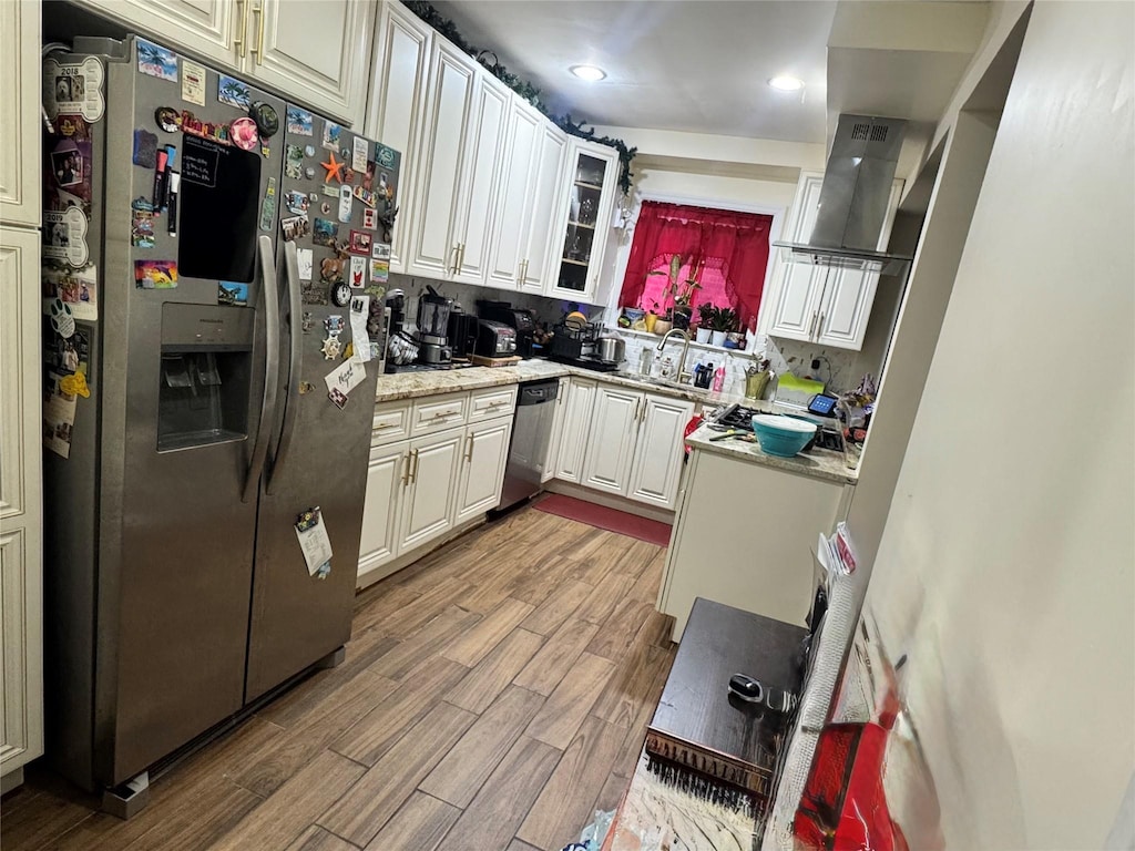 945 E 222nd St, Bronx, NY 10469 - kitchen featuring appliances with stainless steel finishes, wood finished floors, wall chimney exhaust hood, glass insert cabinets, and white cabinets