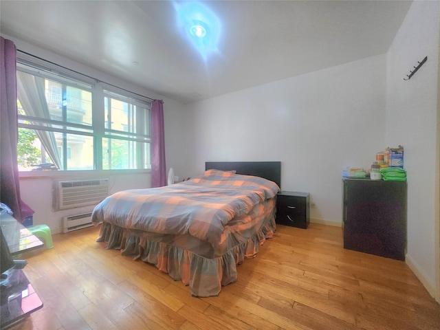 43-17 Union St Unit 2B, Flushing, NY 11355 - bedroom featuring light wood-style flooring, baseboard heating, and a wall mounted air conditioner