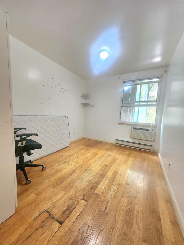 43-17 Union St Unit 2B, Flushing, NY 11355 - unfurnished room with a baseboard radiator, hardwood / wood-style floors, and a wall mounted AC