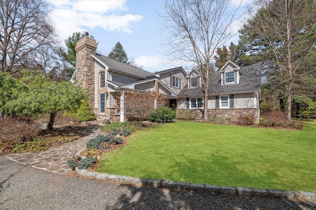 1 Linwood Ln, Northport, NY 11768 - view of front of house with stone siding, a chimney, and a front yard