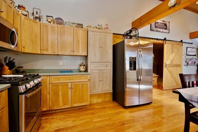 19 W Mitchell St, Smallwood, NY 12778 - kitchen with beam ceiling, appliances with stainless steel finishes, a barn door, light wood-style floors, and light brown cabinetry