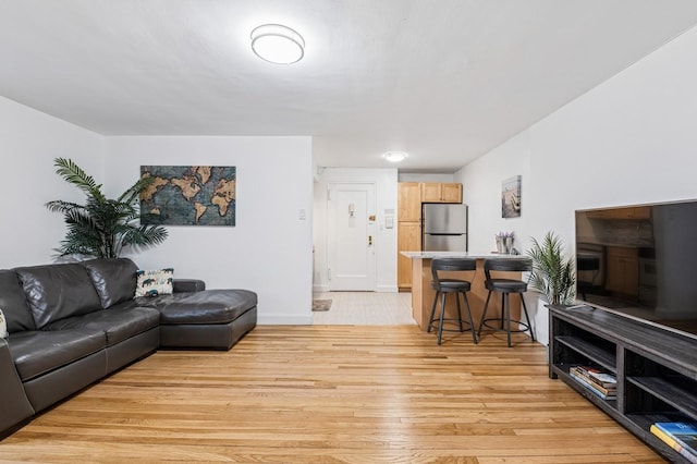 living area with baseboards and light wood finished floors