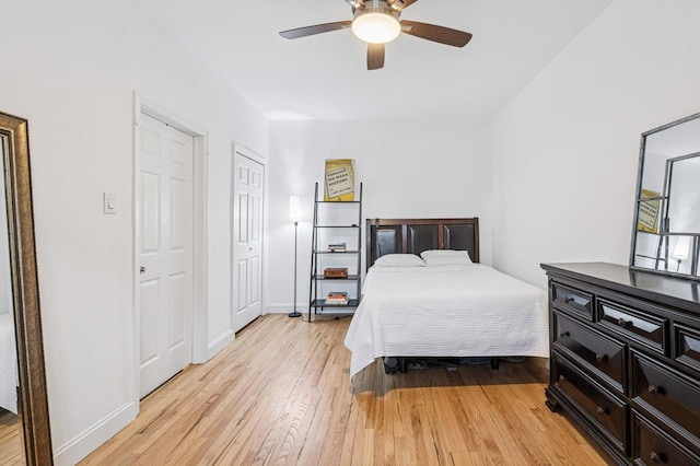 bedroom with ceiling fan, baseboards, and light wood-style flooring