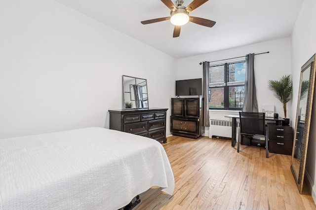 bedroom with radiator, a ceiling fan, and light wood-style floors
