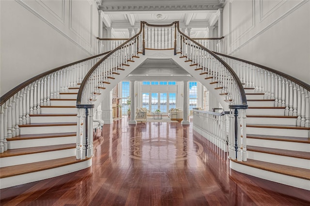 entryway with a high ceiling, stairs, hardwood / wood-style flooring, ornamental molding, and french doors