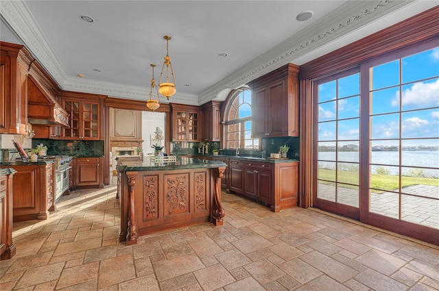kitchen featuring a water view, stone tile flooring, backsplash, glass insert cabinets, and ornamental molding