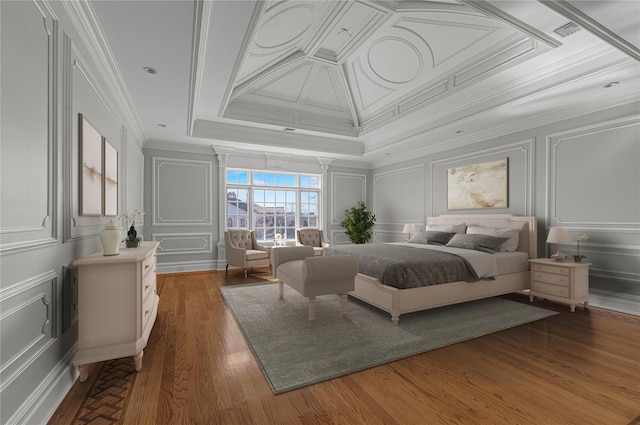 bedroom featuring a decorative wall, crown molding, and wood finished floors