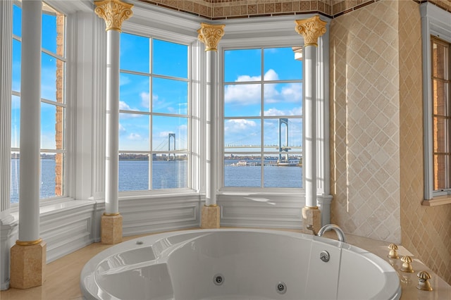 full bathroom with a water view, a whirlpool tub, and plenty of natural light
