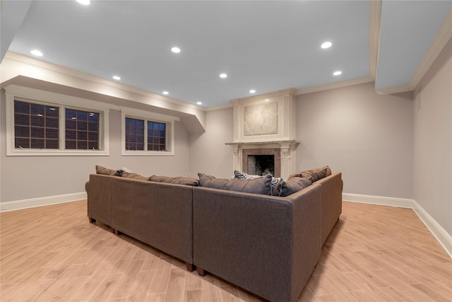 living area with ornamental molding, baseboards, light wood-type flooring, a fireplace, and recessed lighting