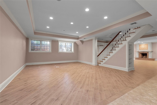 unfurnished living room featuring ornamental molding, a raised ceiling, stairway, baseboards, and recessed lighting